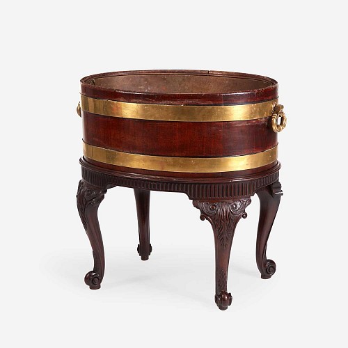 Search:  English Furniture, George III Brass Bound Mahogany Wine Cooler or Cellaret With Liner and Carved Stand, 1765-75, $9,500